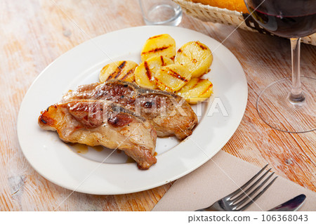 Fried pork on bone with grilled potatoes Fried pork on bone with grilled potatoes 106368043