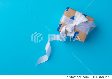 Top view of gift box with ribbon on blue background 106368044