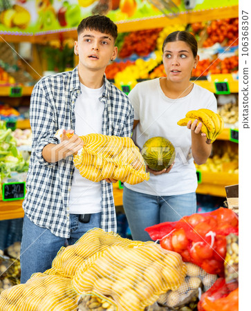Happy young couple chooses products Happy young couple chooses products 106368307