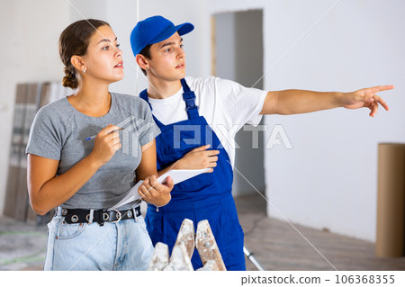 Young worker discusses project documentation of desing with a girl client Young worker discusses project documentation of desing with a girl client 106368355