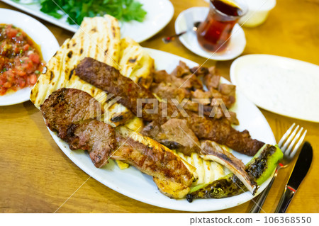 Plate with fried meat, pita bread and stewed peppers. Turkish cuisine Plate with fried meat, pita bread and stewed peppers. Turkish cuisine 106368550