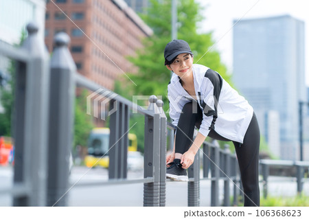 年輕女子在城裡慢跑前做好準備 106368623