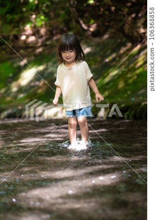 Little girl playing in the stream 106368858