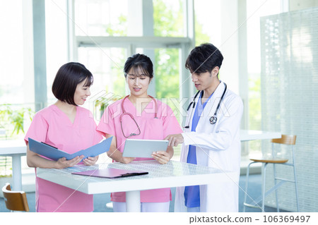Medical image Healthcare workers looking at a tablet 106369497