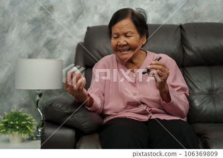 happy senior woman using glucometer checking blood sugar level at home. diabetes concept. good result. happy senior woman using glucometer checking blood sugar level at home. diabetes concept. good result. 106369809
