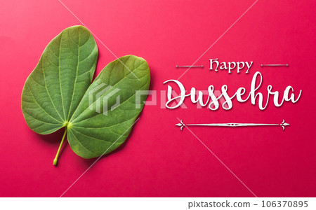 Happy Dussehra background concept made from green leaf and the text on red paper background. Dussehra Indian Festival concept. Happy Dussehra background concept made from green leaf and the text on red paper background. Dussehra Indian Festival concept. 106370895