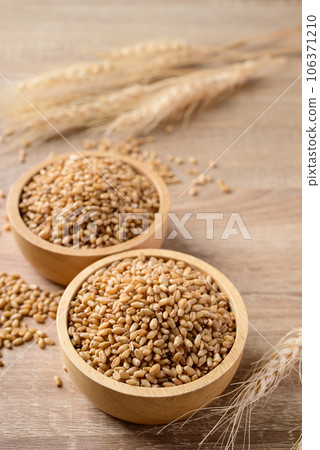 Whole wheat grain in bowl on wooden background, Food ingredients 106371210