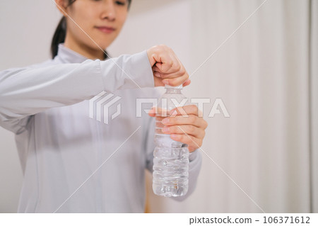 Close-up of woman's hand during diet training drinking water Close-up of woman's hand during diet training drinking water 106371612