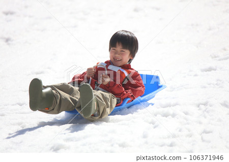 boy playing on a sled boy playing on a sled 106371946