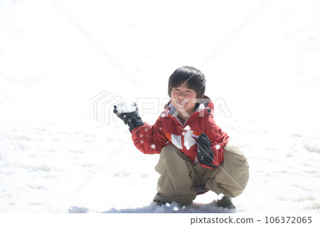 Boy playing in the snow 106372065