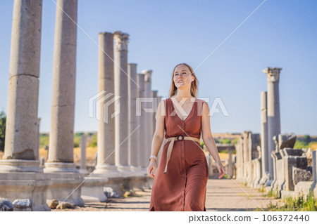Pretty tourist woman at the ruins of ancient city of Perge near Antalya Turkey 106372440