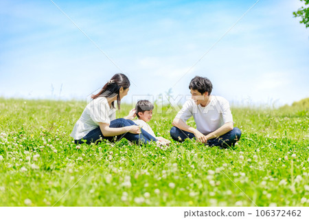 哭泣的兒子和家人坐在藍天的草地上 哭泣的兒子和家人坐在藍天的草地上 106372462