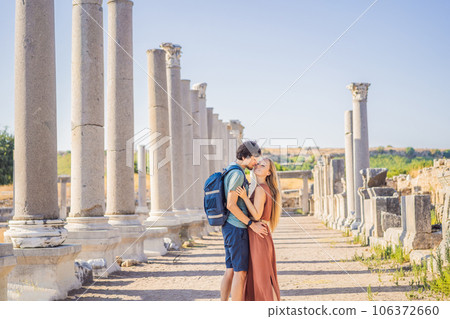 Loving couple of tourists at the ruins of ancient city of Perge near Antalya Turkey. Traveling with kids concept Loving couple of tourists at the ruins of ancient city of Perge near Antalya Turkey. Traveling with kids concept 106372660