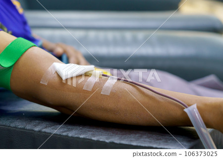 man as blood donor at donation with a bouncy ball holding in hand 106373025
