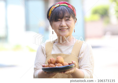 Woman with handmade sata andagi 106373135