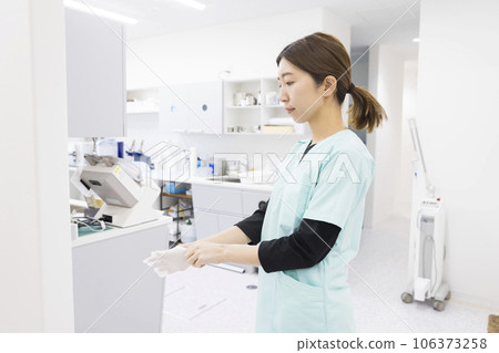 Dental treatment image: Dental hygienist wearing gloves in preparation for treatment 106373258