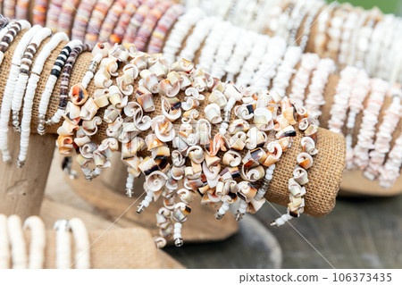 Bracelets made of colorful shells are in souvenir shop 106373435