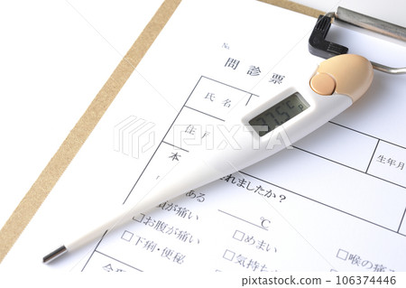 Photograph of the medical questionnaire and thermometer against a white background 106374446