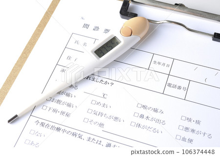 Photograph of the medical questionnaire and thermometer against a white background 106374448