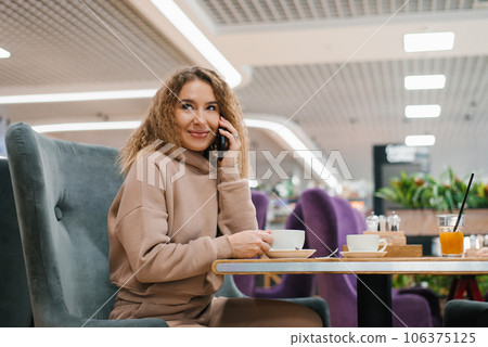Young beautiful caucasian woman talking on smartphone in cafe 106375125