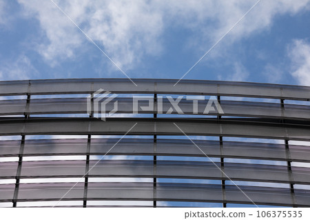A modern sports hall with a panel facade that mimics louvers. 106375535