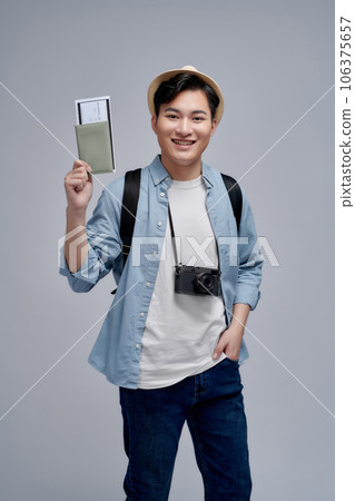Smiling young man student in backpack hold books passport boarding pass tickets 106375657