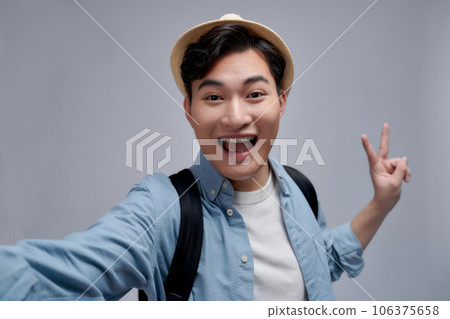 Self portrait of cheerfu blogger showing peace symbol with two fingers to the camera, making video for his blog Self portrait of cheerfu blogger showing peace symbol with two fingers to the camera, making video for his blog 106375658