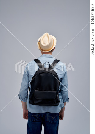 Back view of man with backpack looking up Back view of man with backpack looking up 106375659