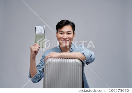 happy asian man with backpack holding passport with air ticket isolated on white happy asian man with backpack holding passport with air ticket isolated on white 106375660