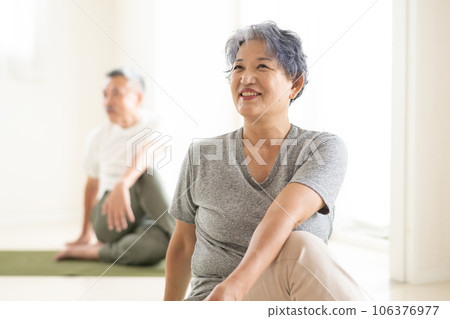 Smiling senior men and women doing yoga 106376977