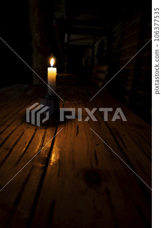 a candle in a dark room is on the table, lack of electricity, saving light, no gas and heat a candle in a dark room is on the table, lack of electricity, saving light, no gas and heat 106377535