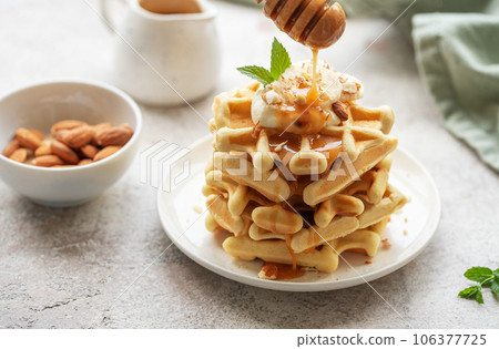Belgian waffles with fruit, bananas and honey. Homemade baking. Belgian waffles with fruit, bananas and honey. Homemade baking. 106377725