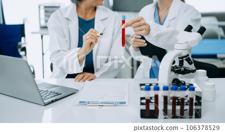 Scientist team meeting and writing analysis results in the laboratory study and analyze scientific sample. Scientist team meeting and writing analysis results in the laboratory study and analyze scientific sample. 106378529