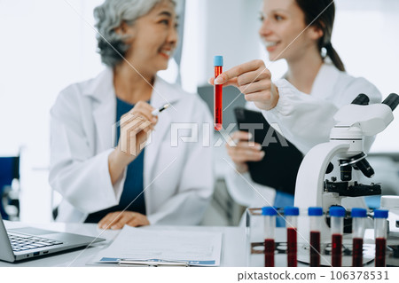 Scientist team meeting and writing analysis results in the laboratory study and analyze scientific sample. 106378531