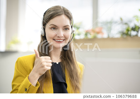 一位微笑的外國女士打開對講機並與她的電腦交談在線英語會話課程圖像 106379688