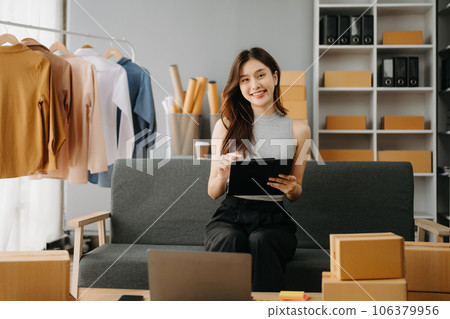 Fashion blogger concept, Young Asian women selling clothes on video streaming.Startup small business SME, using smartphone or tablet taking receive and checking. Fashion blogger concept, Young Asian women selling clothes on video streaming.Startup small business SME, using smartphone or tablet taking receive and checking. 106379956