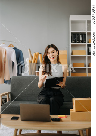 Fashion blogger concept, Young Asian women selling clothes on video streaming.Startup small business SME, using smartphone or tablet taking receive and checking. 106379957