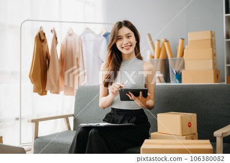 Fashion blogger concept, Young Asian women selling clothes on video streaming.Startup small business SME, using smartphone or tablet taking receive and checking. Fashion blogger concept, Young Asian women selling clothes on video streaming.Startup small business SME, using smartphone or tablet taking receive and checking. 106380082