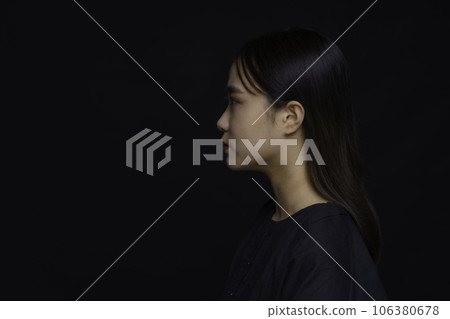 Profile of young woman on black background 106380678