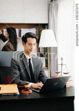Asian lawyer man working with a laptop and tablet in a law office. Legal and legal service concept. Looking at camera in modern office. 106381078