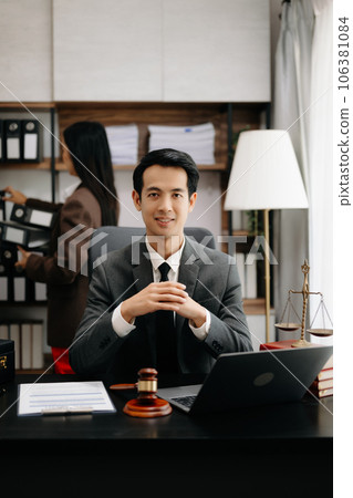 Asian lawyer man working with a laptop and tablet in a law office. Legal and legal service concept. Looking at camera in modern office. Asian lawyer man working with a laptop and tablet in a law office. Legal and legal service concept. Looking at camera in modern office. 106381084