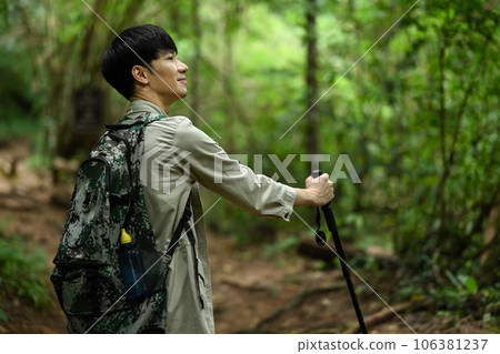 Male hiker with backpack walking along the forest path. Traveling, trekking and adventure concept 106381237