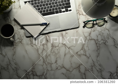 Laptop, notepad, coffee cup and glasses on marble. Top view with copy space for text Laptop, notepad, coffee cup and glasses on marble. Top view with copy space for text 106381260