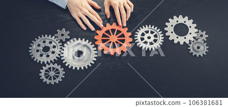 Man hands putting a cogwheel into a common mechanism. Man hands putting a cogwheel into a common mechanism. 106381681