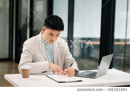 Young Asian business man working at office with laptop, tablet and taking notes on the paper. 106381894