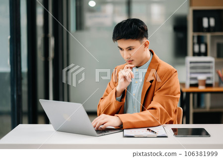Young Asian business man working at office with laptop, tablet and taking notes on the paper. 106381999