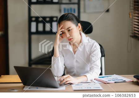 Asian business woman is stressed, bored, and overthinking from working on a tablet at the  office... 106382653