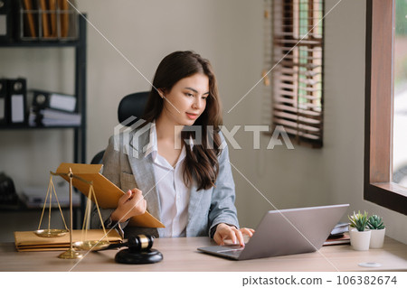 Beautiful asian woman lawyer working and gavel, tablet, laptop in front, Advice justice and law concept.. 106382674