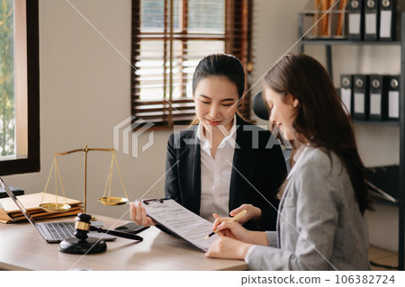 Judge gavel with scales of justice, Business and lawyer or counselor consulting and discussing contract papers with laptop and tablet at law firm in office. 106382724