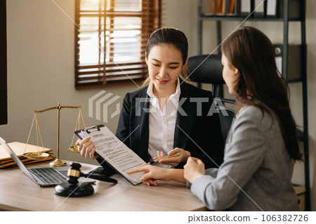 Business and lawyer or counselor consulting and discussing contract papers with laptop and tablet at law firm in office. 106382726